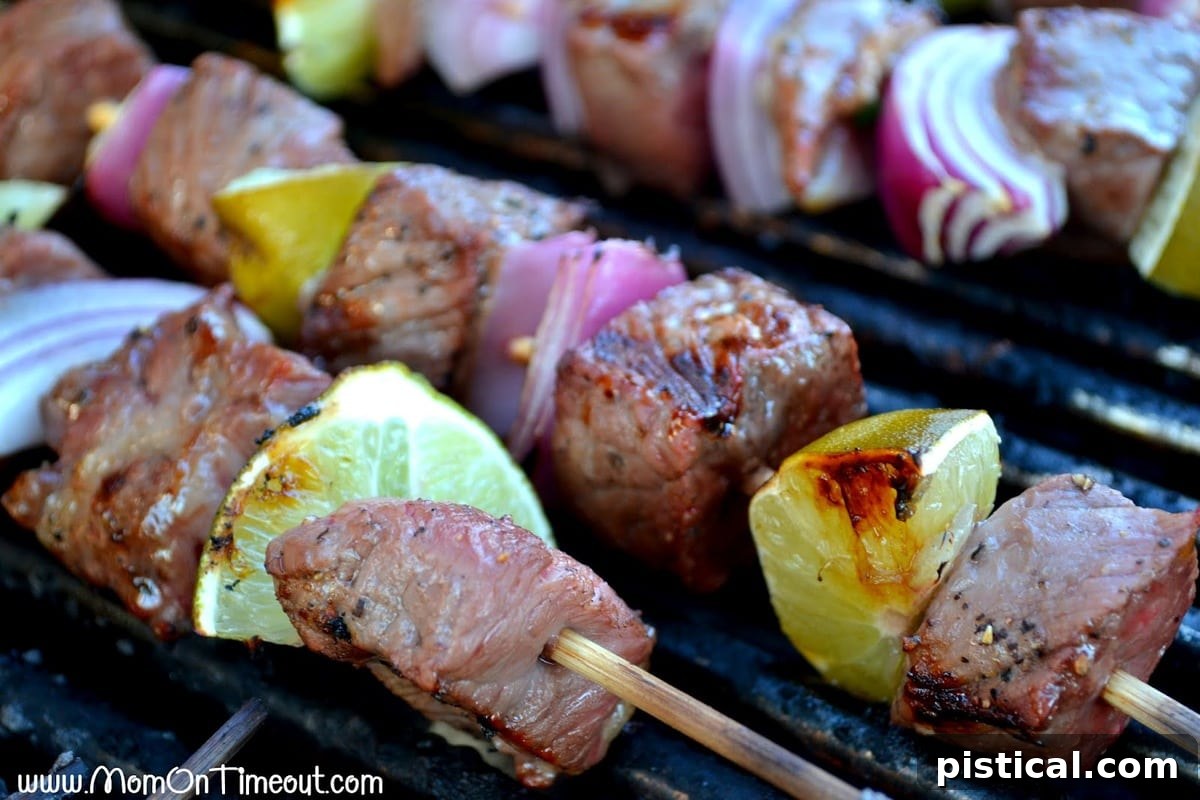 Mojo Beef Kabobs sizzling on a hot grill, showcasing perfect char marks and vibrant colors.
