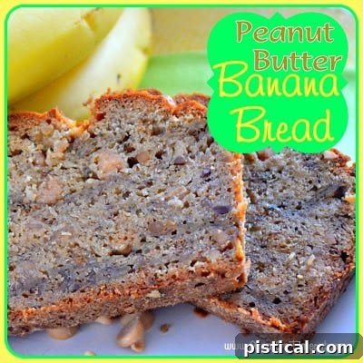 Two perfectly sliced pieces of moist Peanut Butter Banana Bread sit on a white plate, with a ripe banana artfully placed behind them.
