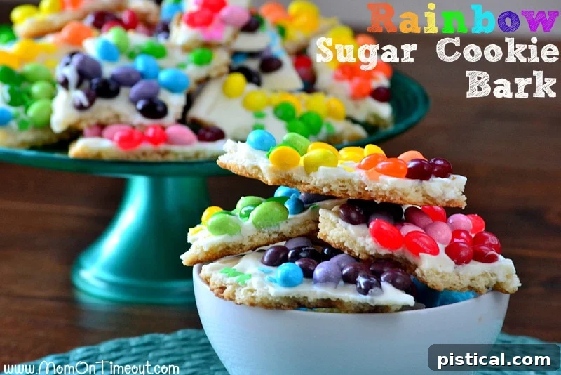 Vibrant Rainbow Sugar Cookie Bark, showcasing the colorful candy arranged on a vanilla candy coating over a sugar cookie base. Close-up of freshly made Rainbow Sugar Cookie Bark before breaking