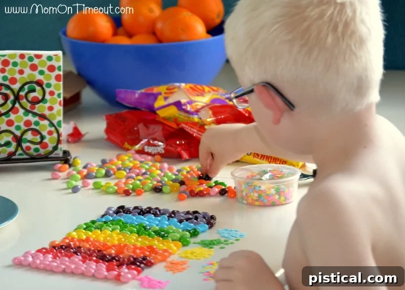 Kaleidoscope Cookie Bark 2 Young boy Reece happily sorting rainbow candies into separate containers