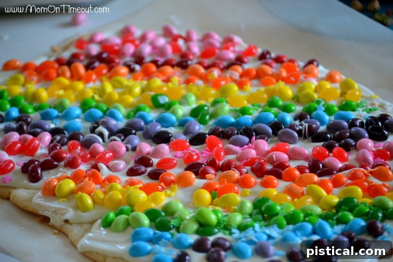 The completed Rainbow Sugar Cookie Bark, showcasing the beautiful arrangement of candies. Fully decorated Rainbow Sugar Cookie Bark with two complete rainbows before being broken into pieces