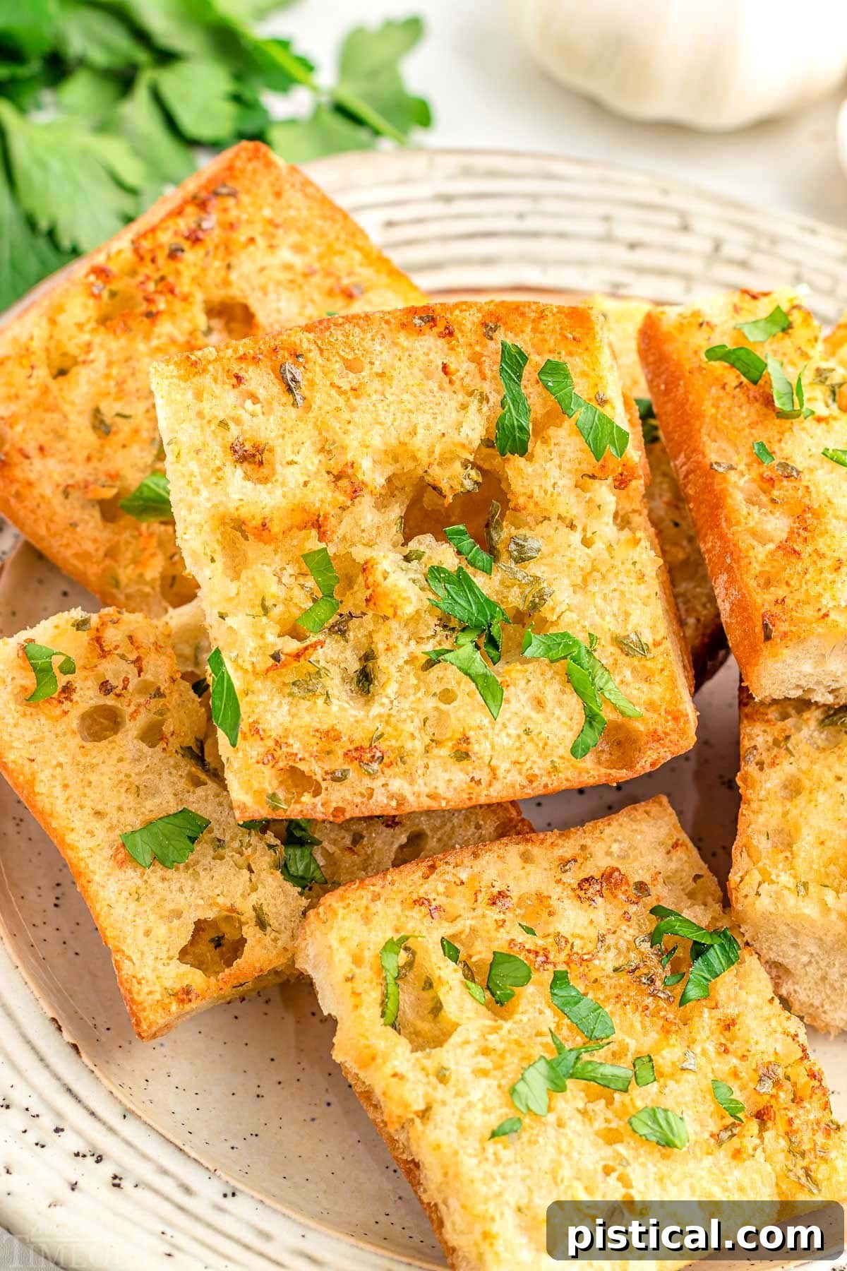 A plate featuring six or seven pieces of golden-brown Air Fryer Garlic Bread, beautifully garnished with fresh chopped parsley.
