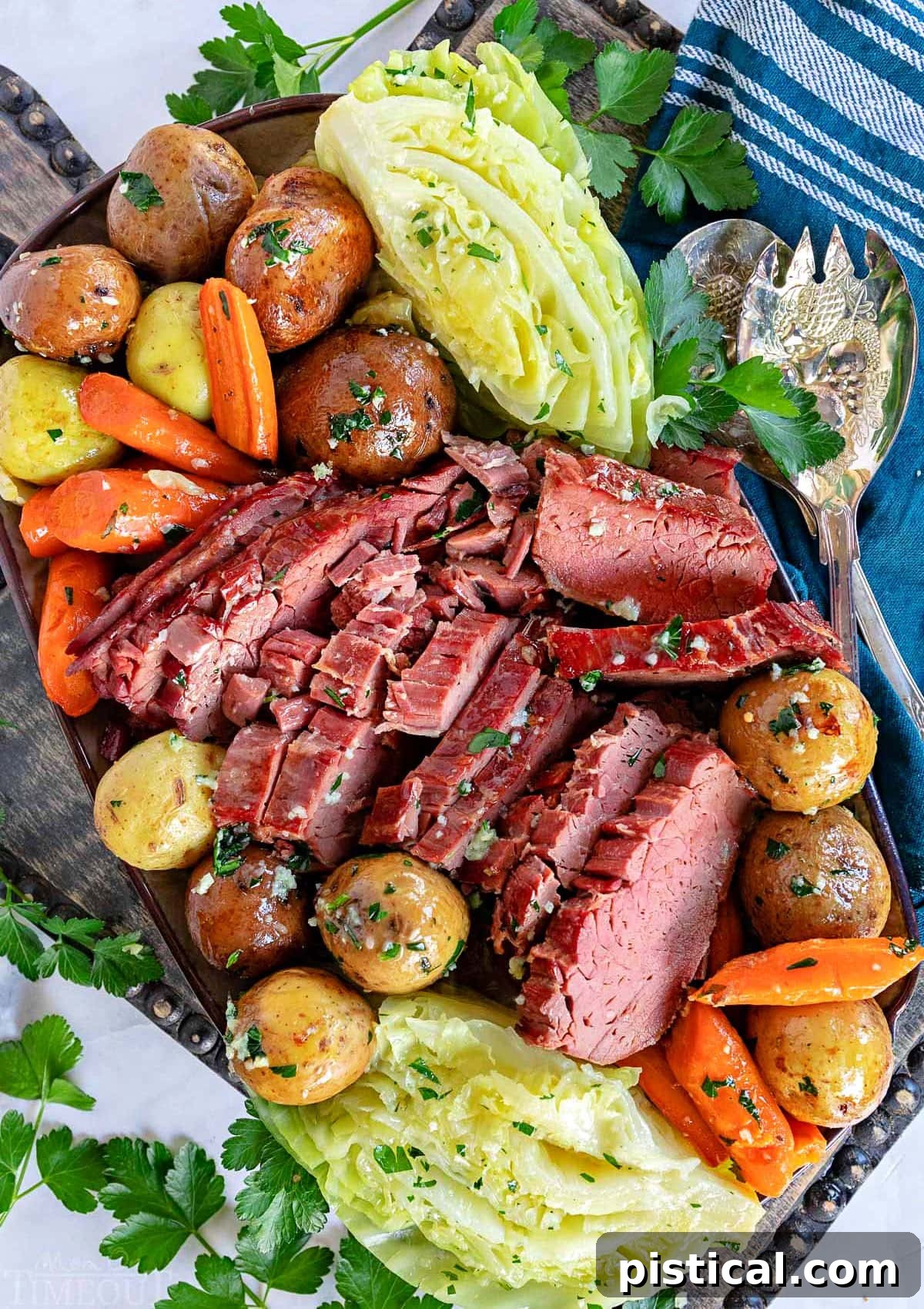top down look at crockpot corned beef cut up with cabbage, carrots and potatoes all arranged on a serving platter ready to be served.