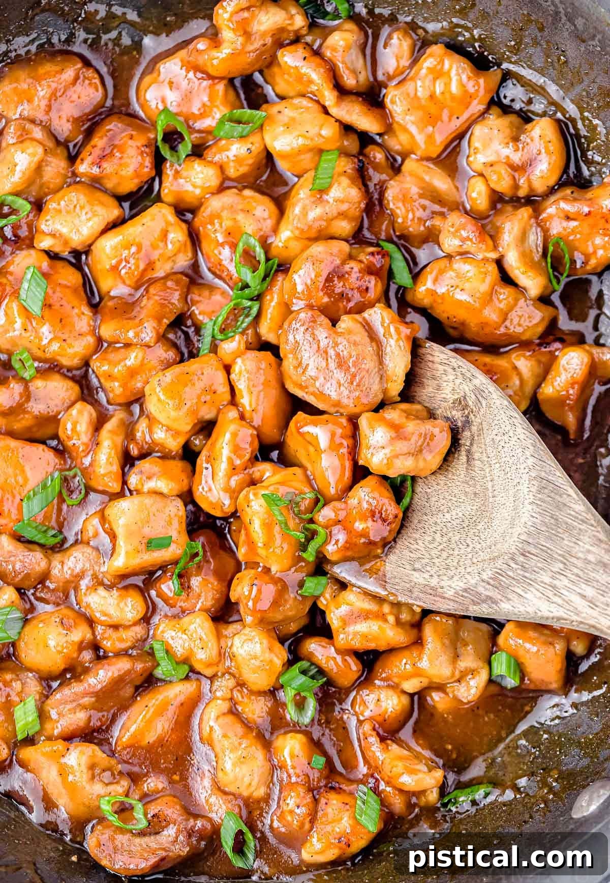 Sticky Honey Garlic Chicken 2 top down look at honey chicken in large black skillet cooked through and ready to be served with rice or steamed veggies.