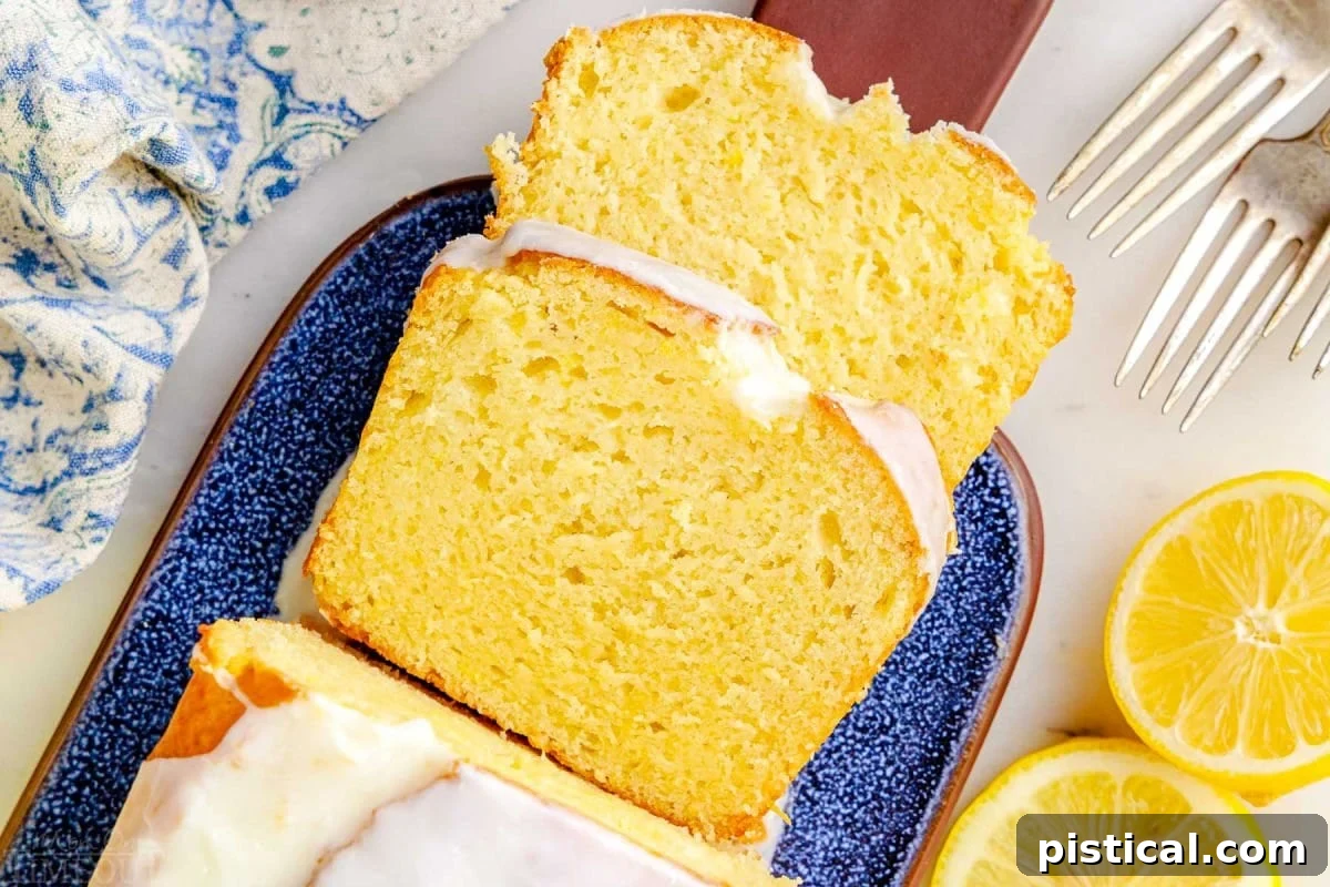 top down look at two slices of limoncello cake on a blue glazed clay cutting board. you can see the rest of the loaf and the glaze on top as well.