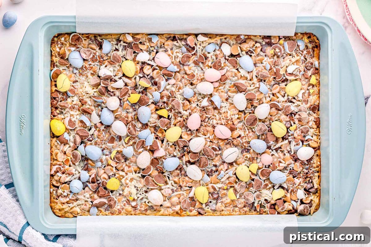 light blue metal baking tray with baked magic cookie bars topped with cadbury eggs.
