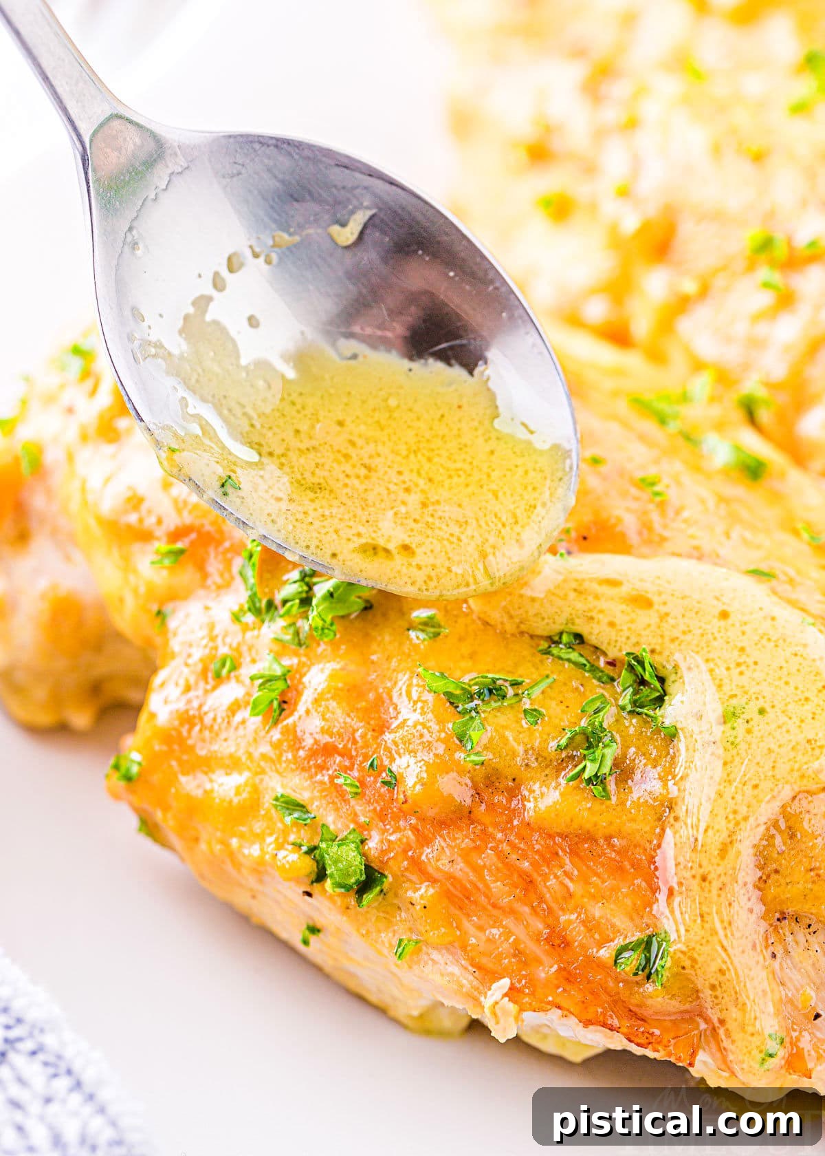 Golden-brown honey mustard chicken breast being generously drizzled with its savory sauce.