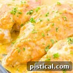honey mustard chicken breasts baked in a glass baking dish ready to be served all topped with a savory honey mustard sauce.