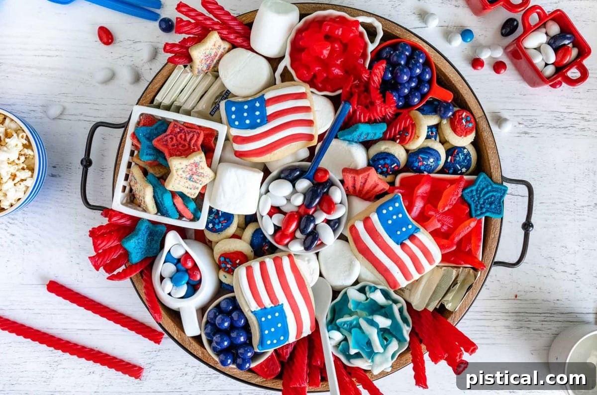 Red, White & Blue Grazing Board 7 top down look at wood charcuterie board loaded with red white and blue desserts for 4th of july. cookies, candy and all sorts of colorful treats.