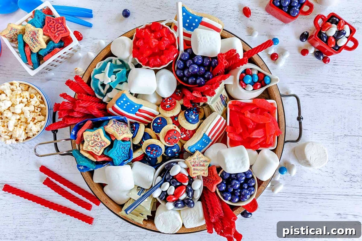 Red, White & Blue Grazing Board 8 top down look at wood charcuterie board loaded with red white and blue desserts for 4th of july. cookies, candy and all sorts of colorful treats.
