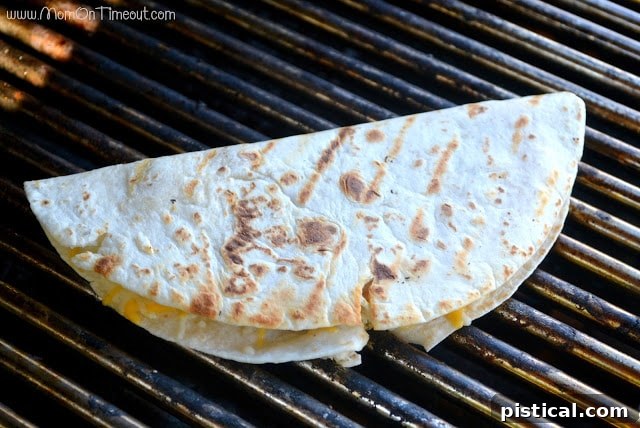 Finished grilled shrimp quesadillas on a wooden board, showcasing perfect grill marks