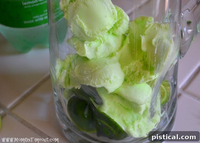 Gamma Green Zest Party Punch 5 Lime sherbet scoops being added into a punch bowl over lime slices, preparing for the party punch.