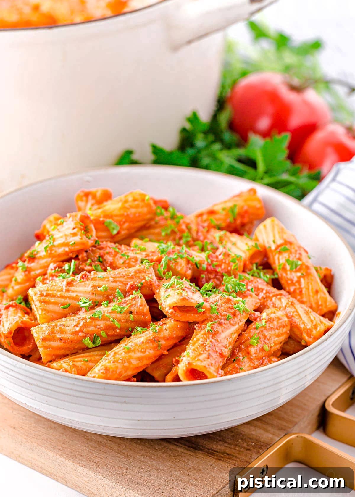 chorizo pasta in a large white pasta bowl sitting in front of large white pot.