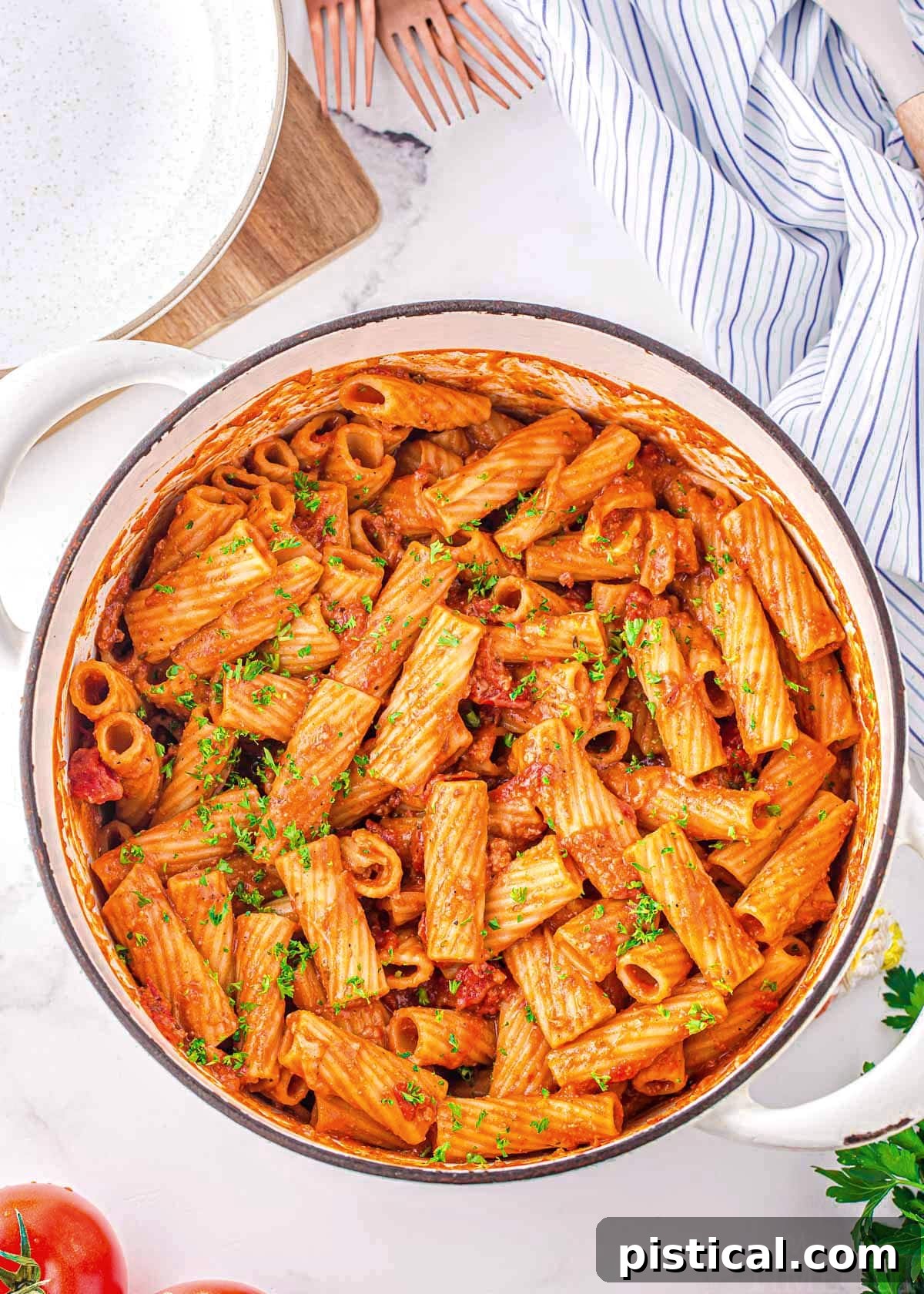 top down look at one pot pasta in a white dutch oven garnished with fresh parsley.