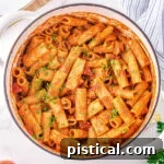 top down look at one pot pasta in a white dutch oven garnished with fresh parsley.