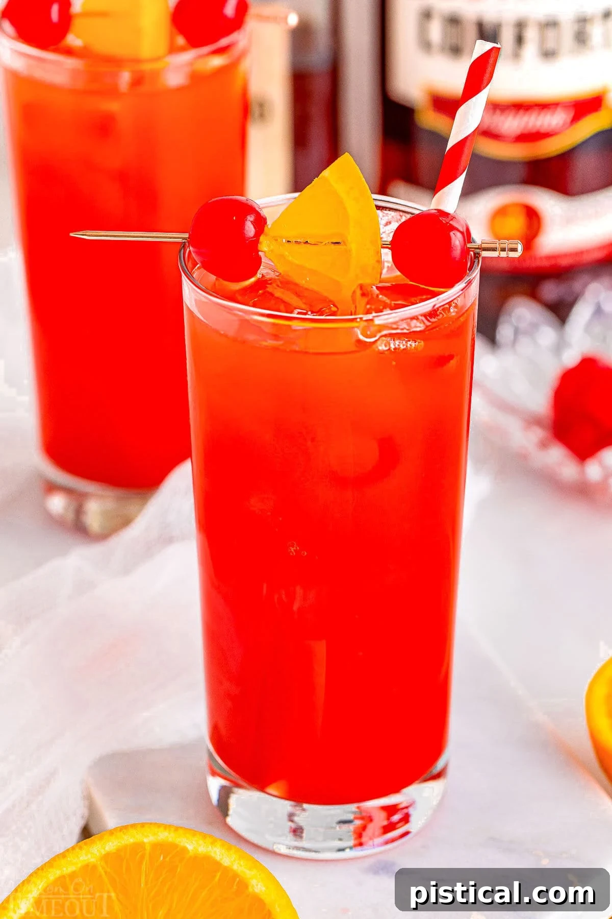 Two vibrant Alabama Slammer drinks, expertly poured and garnished, ready to be enjoyed in tall, clear glasses.
