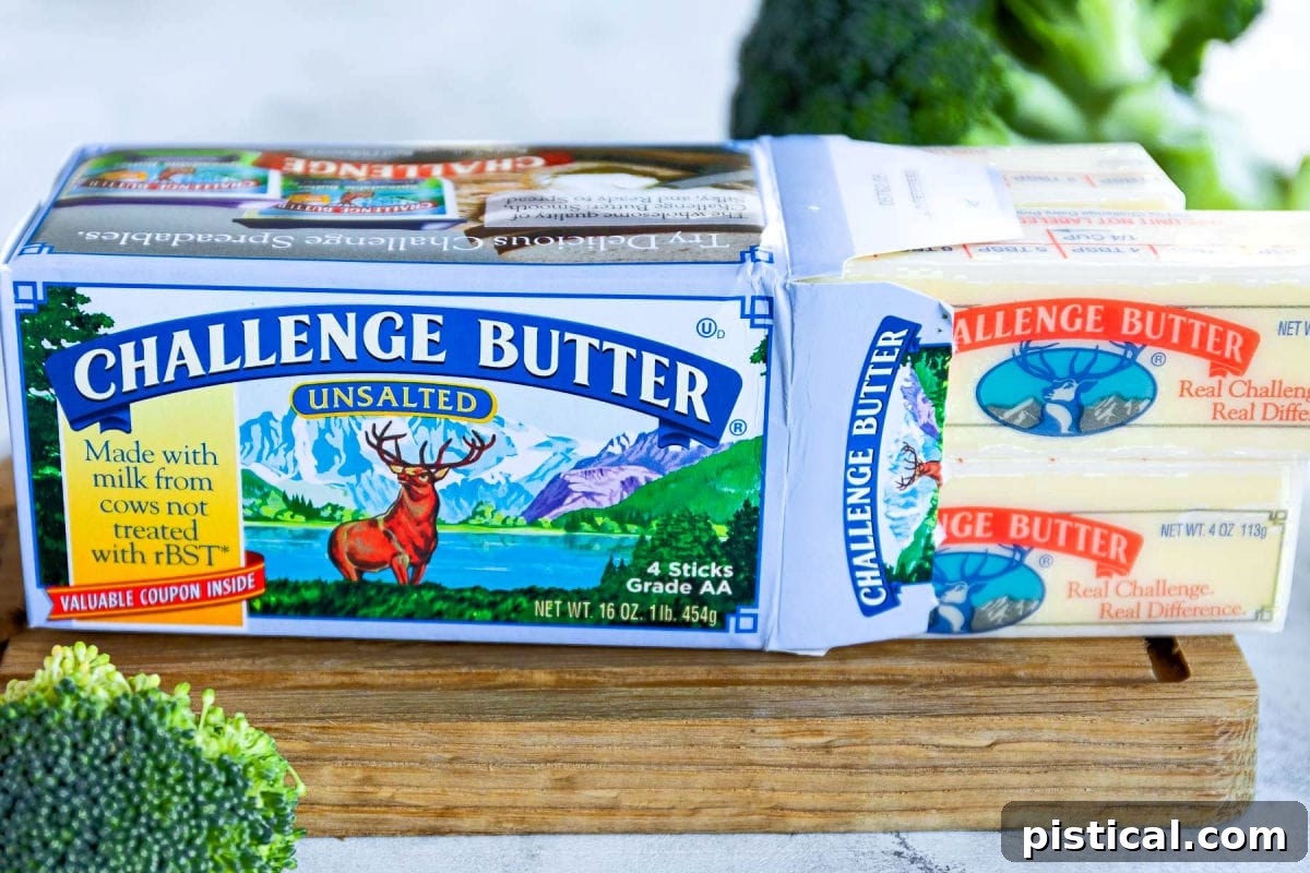 box of challenge unsalted butter on small cutting board with butter sticks pulled out of the side of the box.