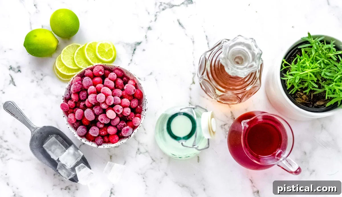 A top-down view of all the ingredients for a Cranberry Moscow Mule laid out on a surface, including cranberry juice, bourbon, ginger beer, lime, ice, and garnishes.