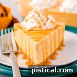 A beautiful piece of no bake pumpkin cheesecake, topped with whipped cream and caramel drizzle, ready to be served.