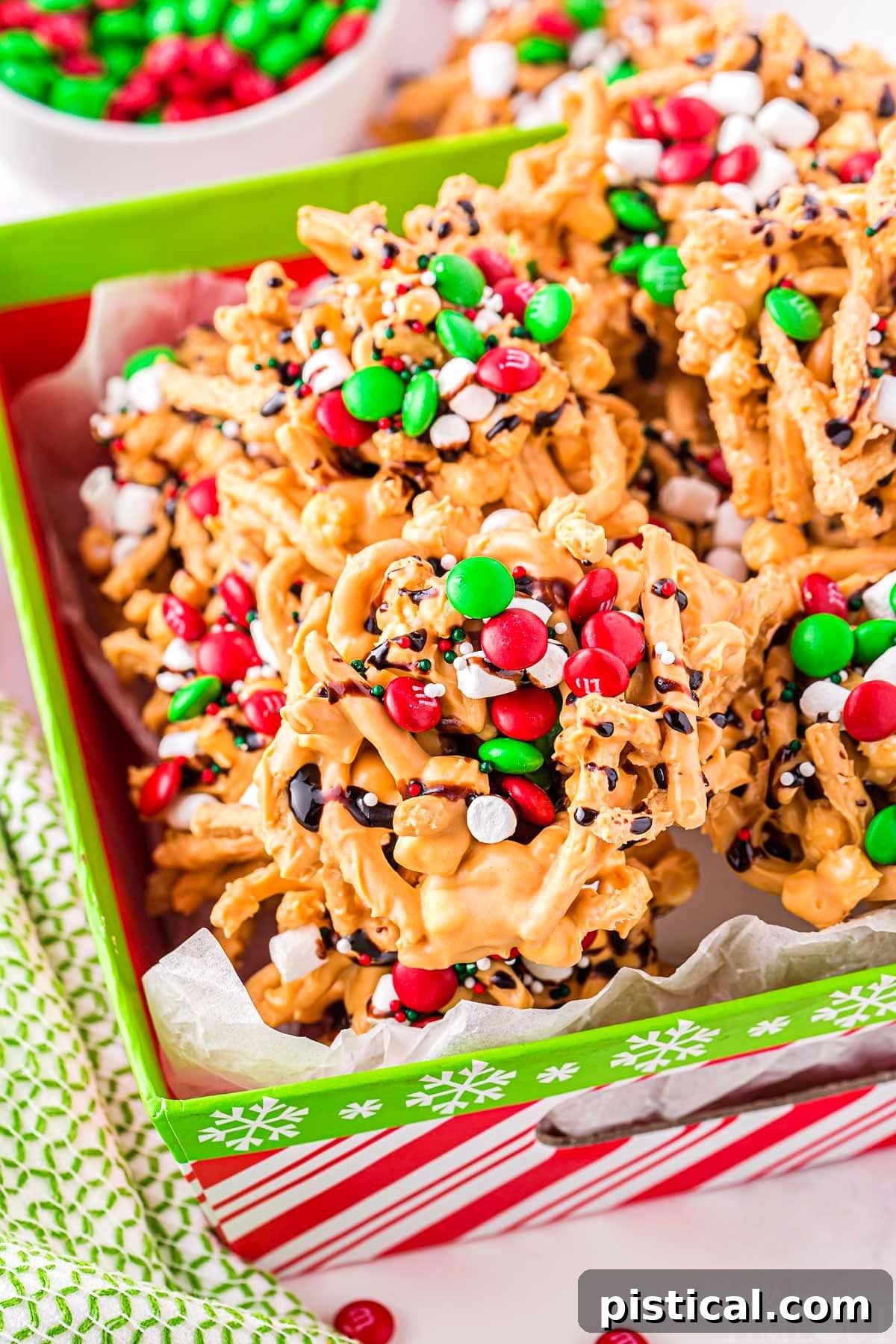 Festive Buddy the Elf Cookies, adorned with colorful candies and marshmallows, presented in a charming red and green Christmas box.