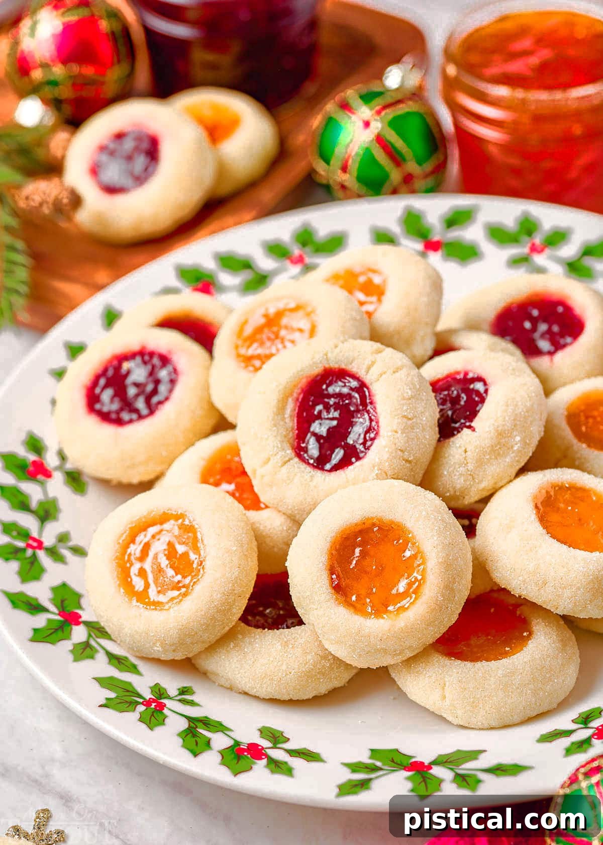 christmas plate piled high with thumbprint cookies filled with apricot and raspberry jam.