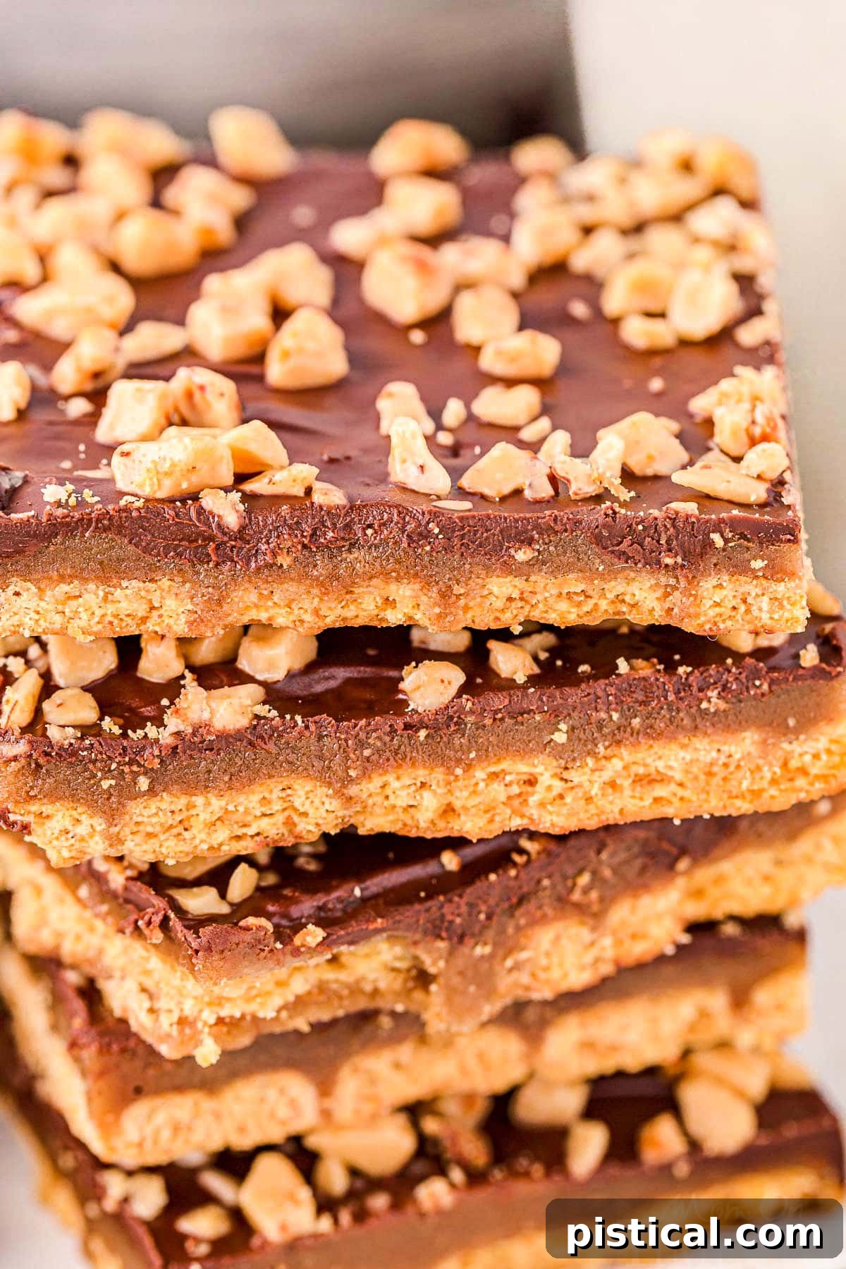 Close up look at stack of graham cracker toffee topped with heath toffee bits, showing off its rich texture.