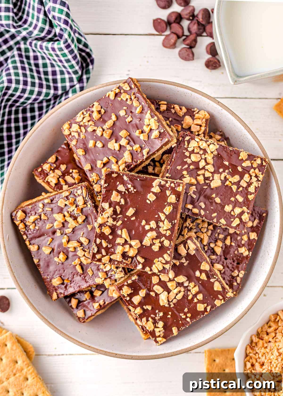 Top down look at white round plate piled high with graham cracker toffee, perfect for sharing.