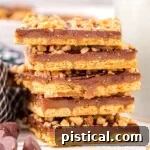 Six pieces of graham cracker toffee stacked on top of each other with some chocolate chips scattered in front.