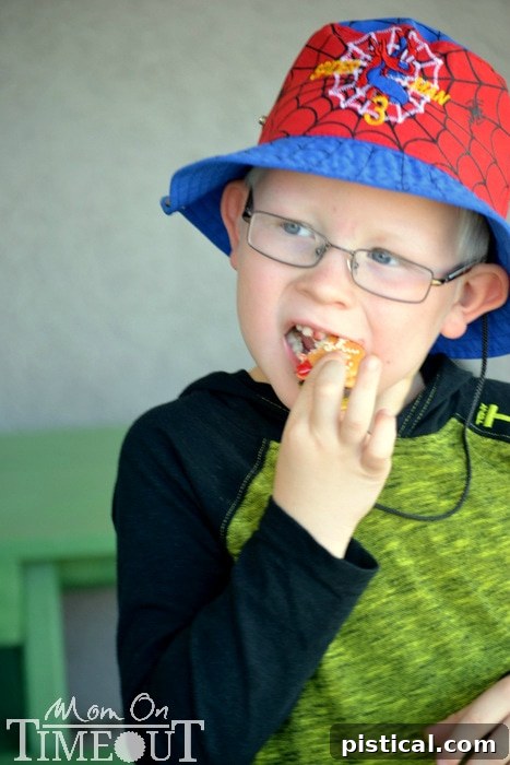 A child enthusiastically eating a cookie slider, showing pure enjoyment