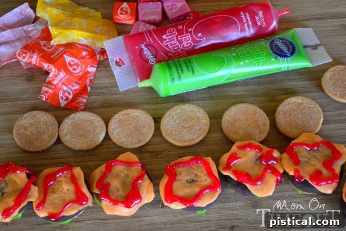 Red frosting drizzled as ketchup over the melted Starburst cheese on a cookie slider