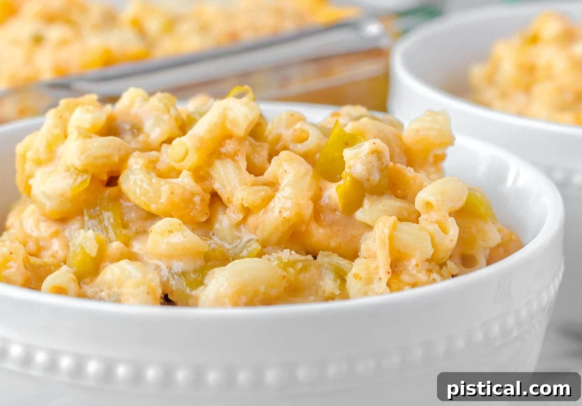 close up look at green chile mac and cheese in a white bowl.