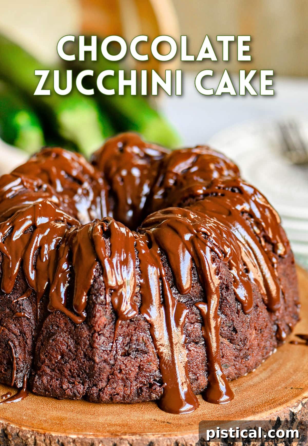 A whole chocolate zucchini bundt cake elegantly presented on a rustic wooden cake stand, featuring a generous, glistening chocolate glaze cascading over its ridges. The image highlights the cake's rich, dark appearance.