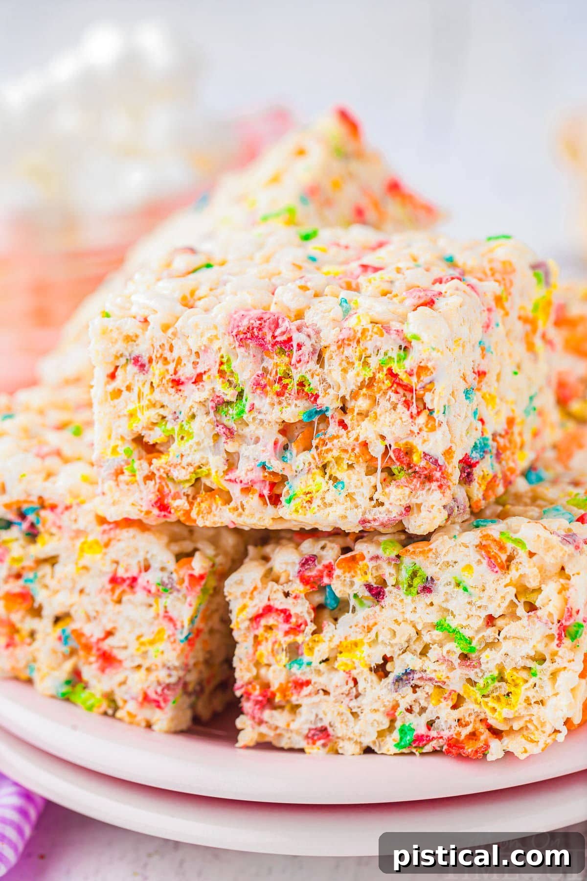 rice krispie treats stacked on light pink plates.