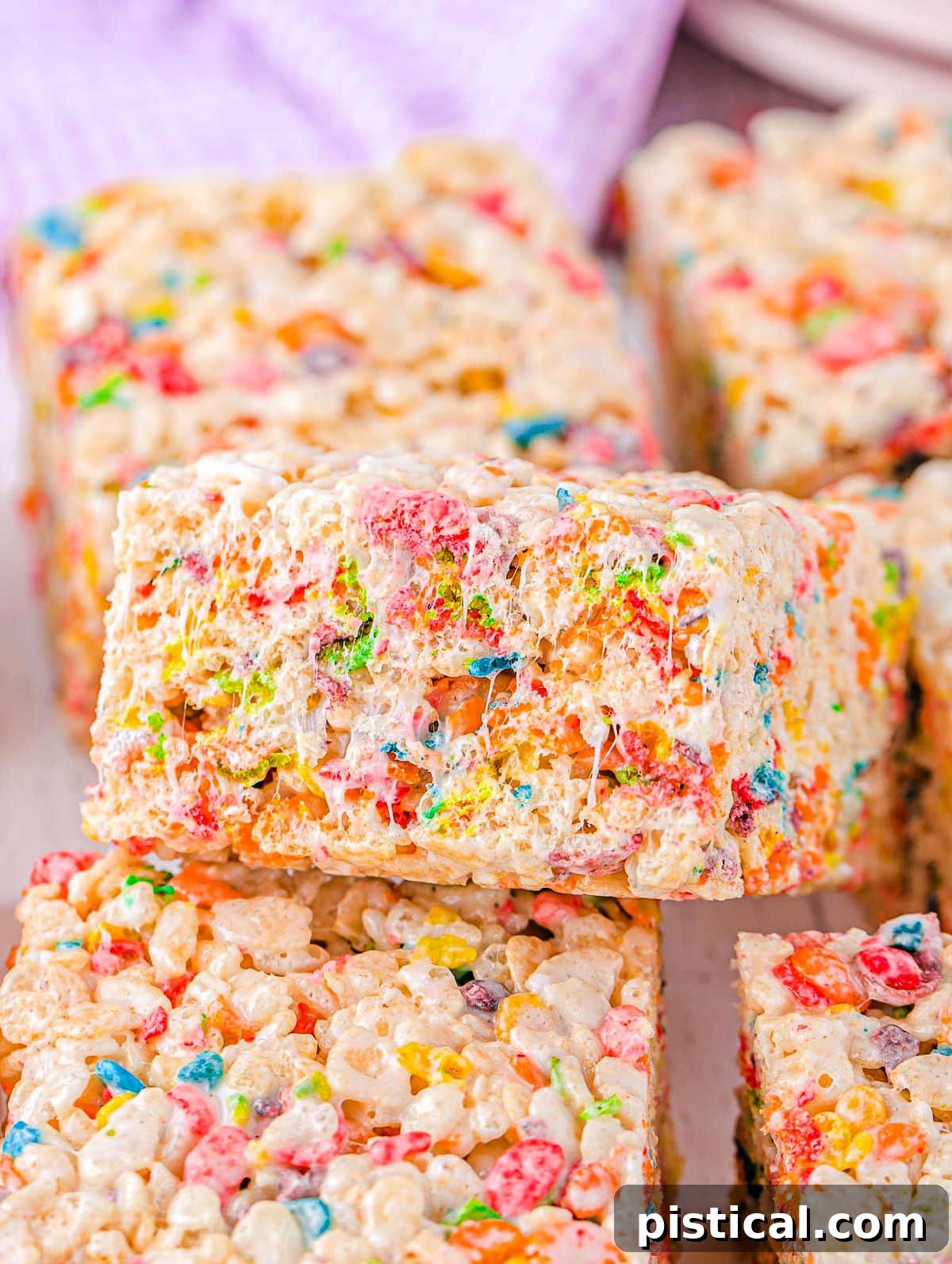 colorful rainbow rice krispie treats cut into squares and ready to enjoy.