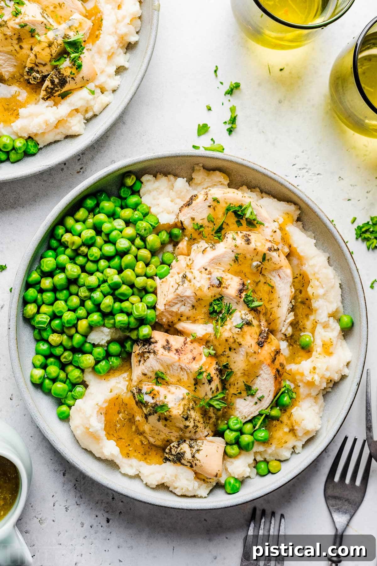Easy Instant Pot Chicken Breast with Velvety Gravy 5 top down look at instant pot chicken breast sliced sitting on a bed of mashed potatoes with gravy over the top. green peas are also on the plate.