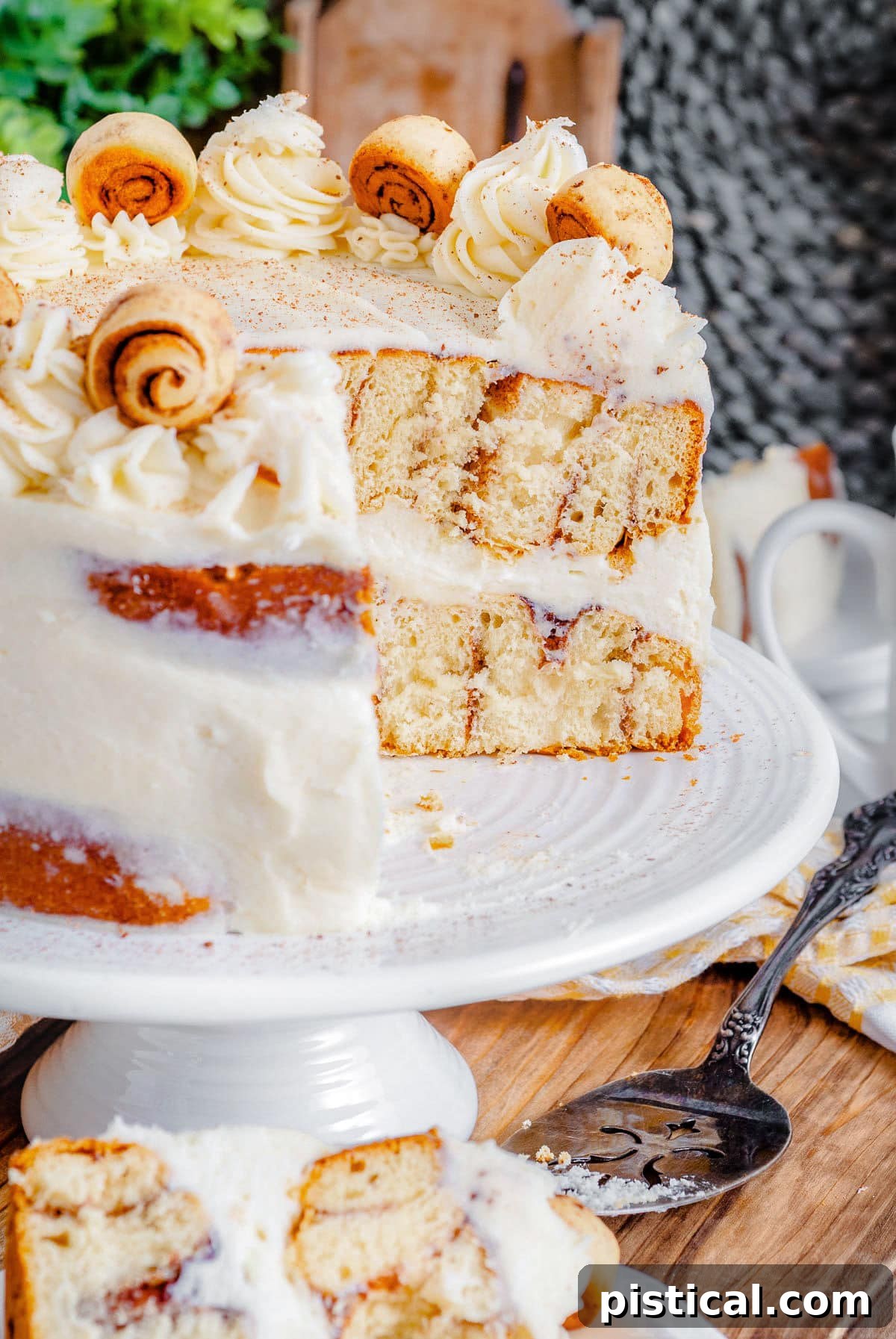 Decadent Cinnamon Swirl Layer Cake 10 A profile view of the Cinnamon Roll Layer Cake with a slice removed, clearly revealing the beautiful internal cinnamon swirls and the generous layers of frosting.