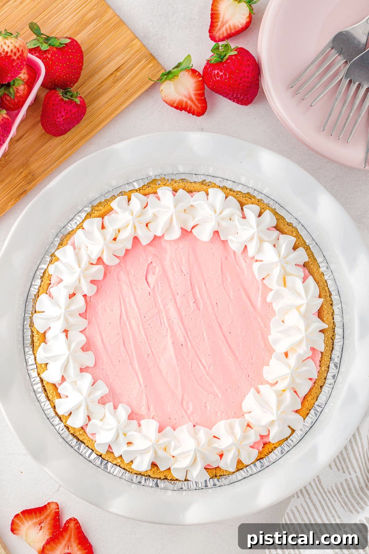 A top-down view of a beautifully set Kool Aid Pie, generously topped with fluffy whipped cream, invitingly ready to be sliced and enjoyed for a refreshing treat.