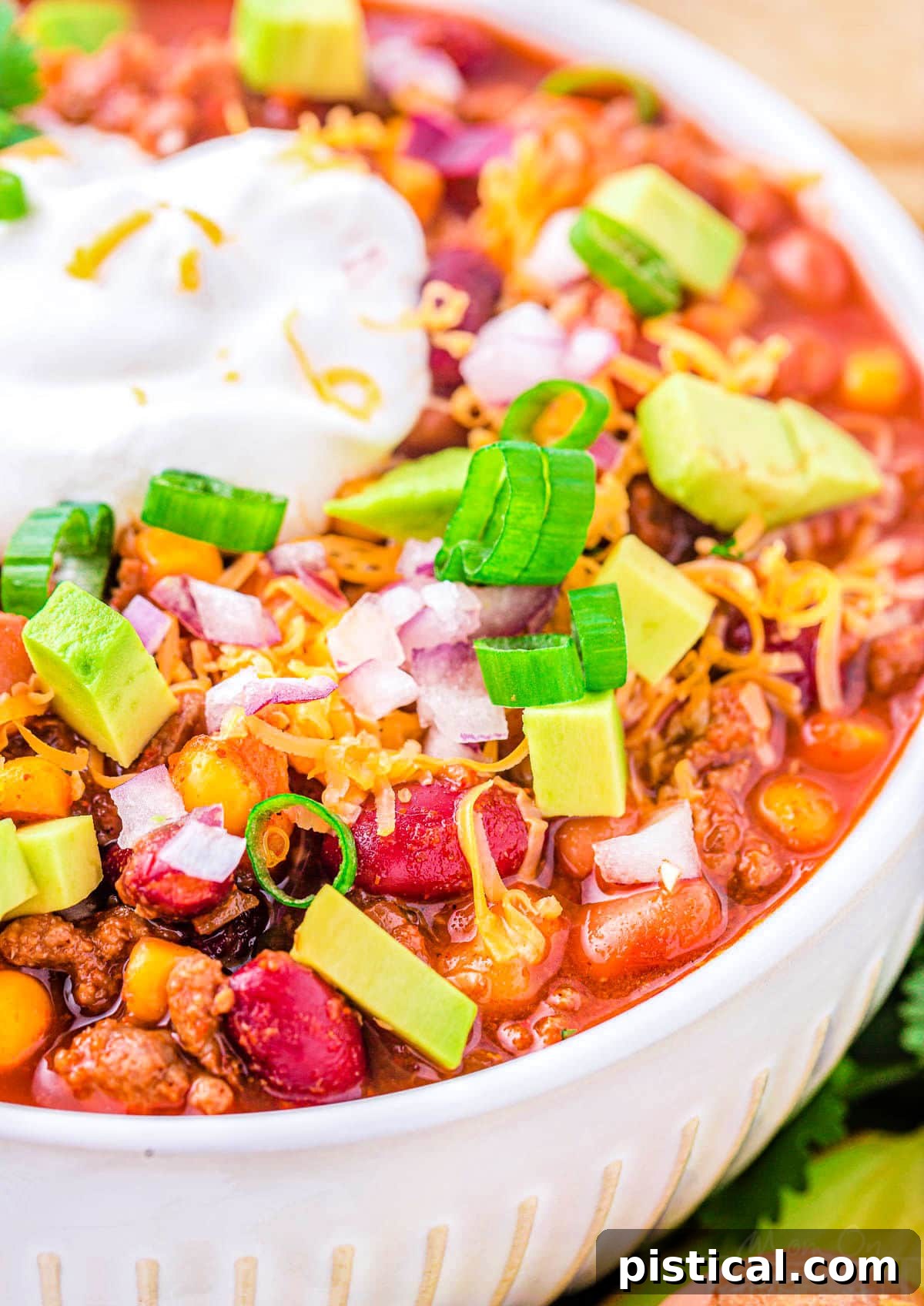 close up look at bowl of taco soup loaded with fresh toppings and sour cream.