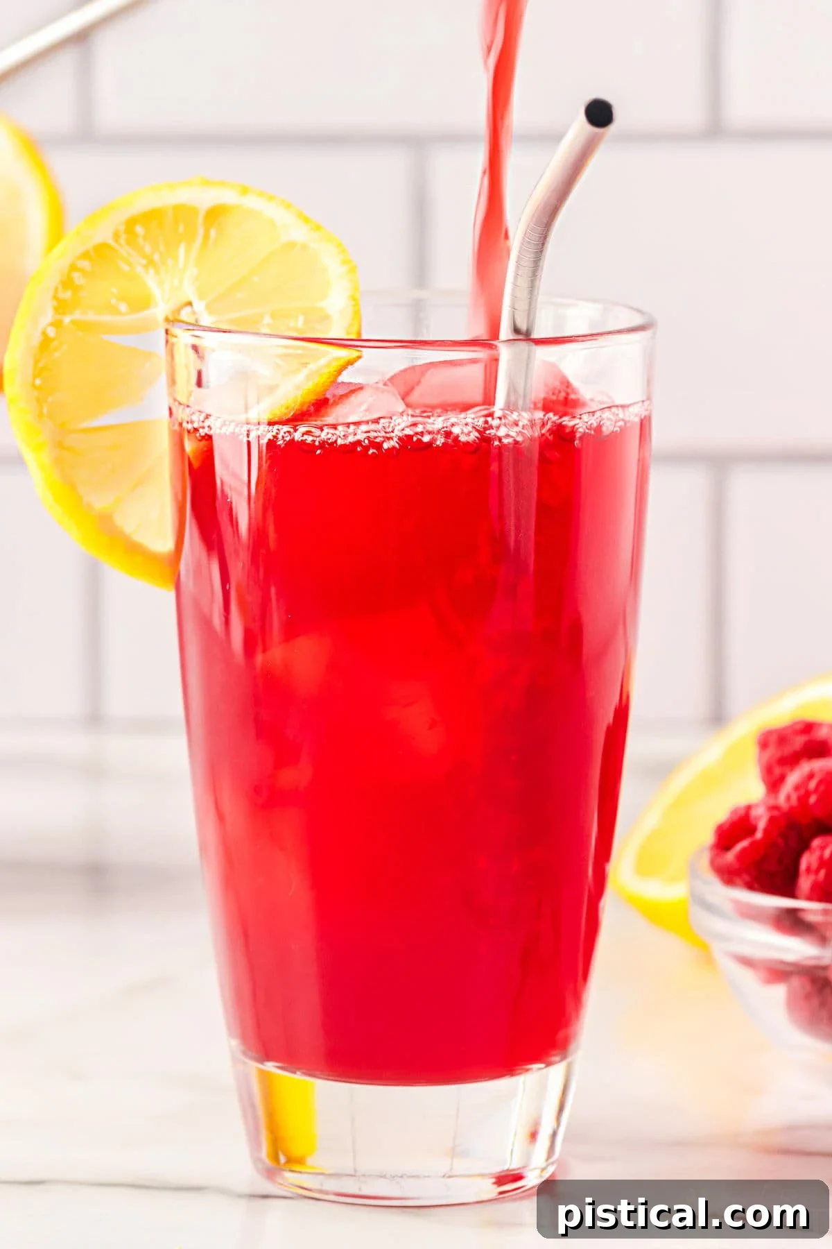 Ruby Red Raspberry Refresher 6 raspberry tea being poured into a tall glass.