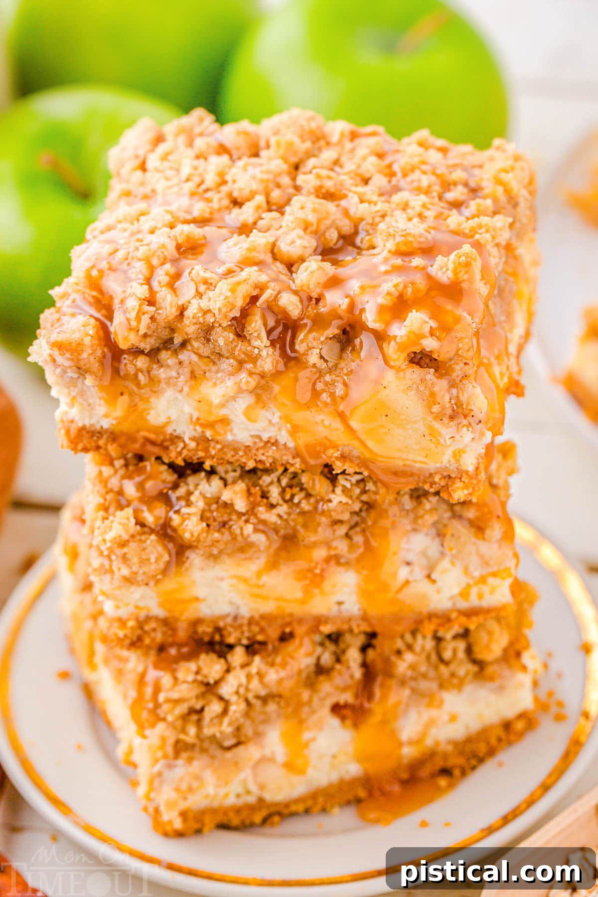 Spiced Caramel Apple Cheesecake Bars 6 Three caramel apple cheesecake bars stacked on a white plate with caramel drizzled on top, showcasing the perfect autumn dessert.