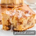 A top-down shot of a slice of apple coffee cake, showing its moist crumb and a light glaze. 