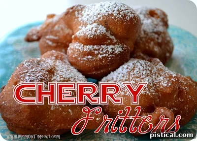 A close-up shot of several fresh cherry fritters, showing their golden-brown texture and the visible cherry pieces within.