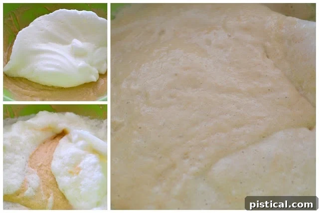 Egg whites being gently folded into a prepared fritter batter with a spatula, showing the light, airy consistency.