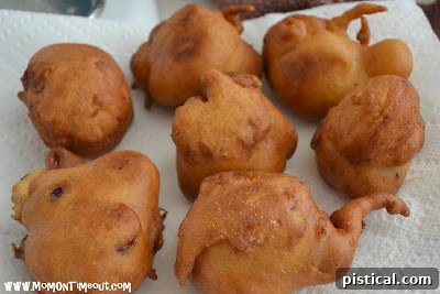 Freshly fried cherry fritters resting on paper towels to drain excess oil.