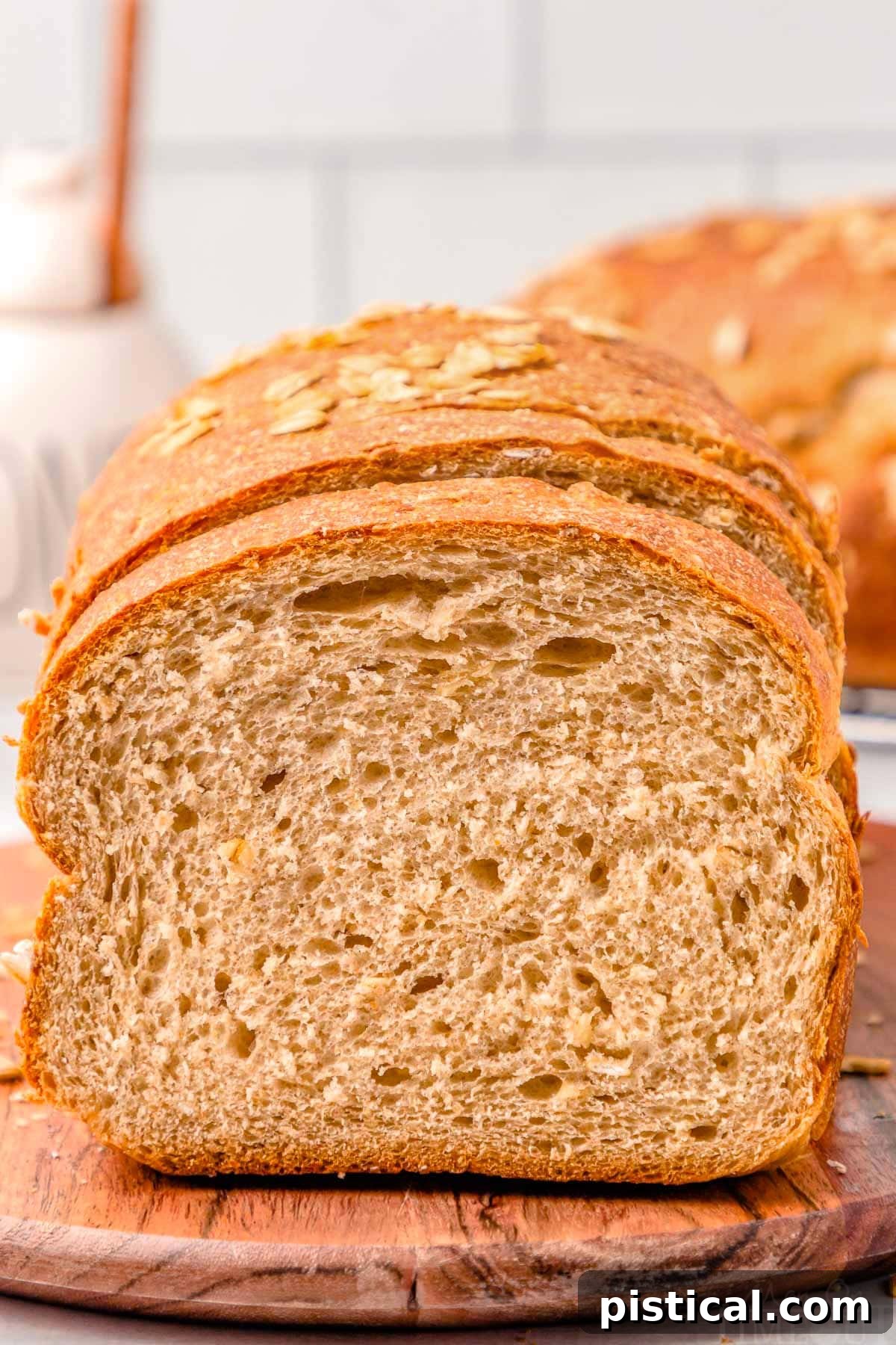 loaf of whole wheat board on a wood board with the end cut off.