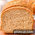 loaf of whole wheat board on a wood board with the end cut off.