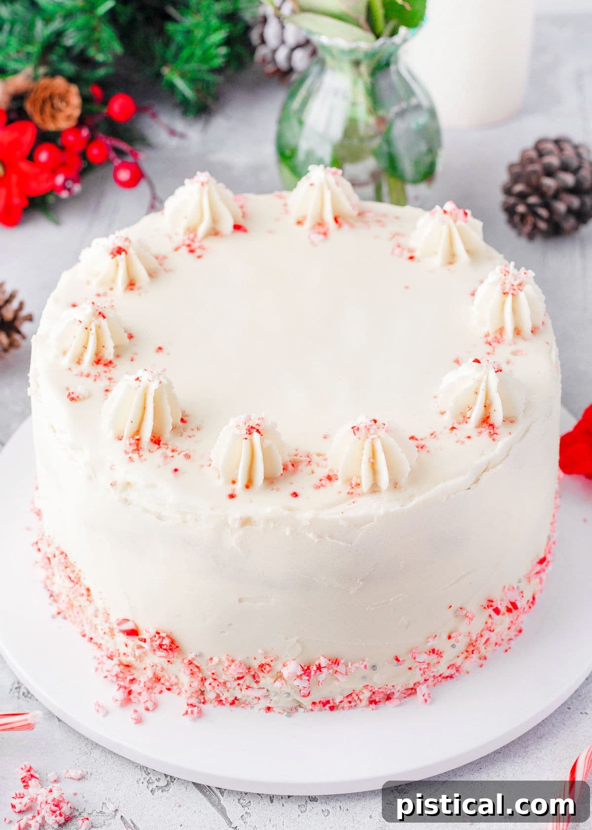 A beautifully decorated whole Peppermint Cake, frosted with smooth peppermint frosting and adorned with candy canes, presented as a festive dessert.