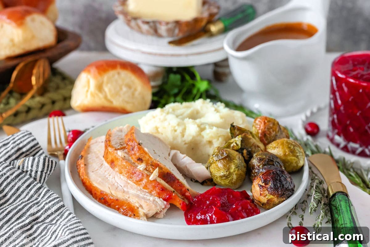 An image showing a plated portion of turkey with classic Thanksgiving side dishes, illustrating how much turkey per person.