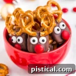 red bowl filled with reindeer pretzels with red candy noses and pretzel antlers.