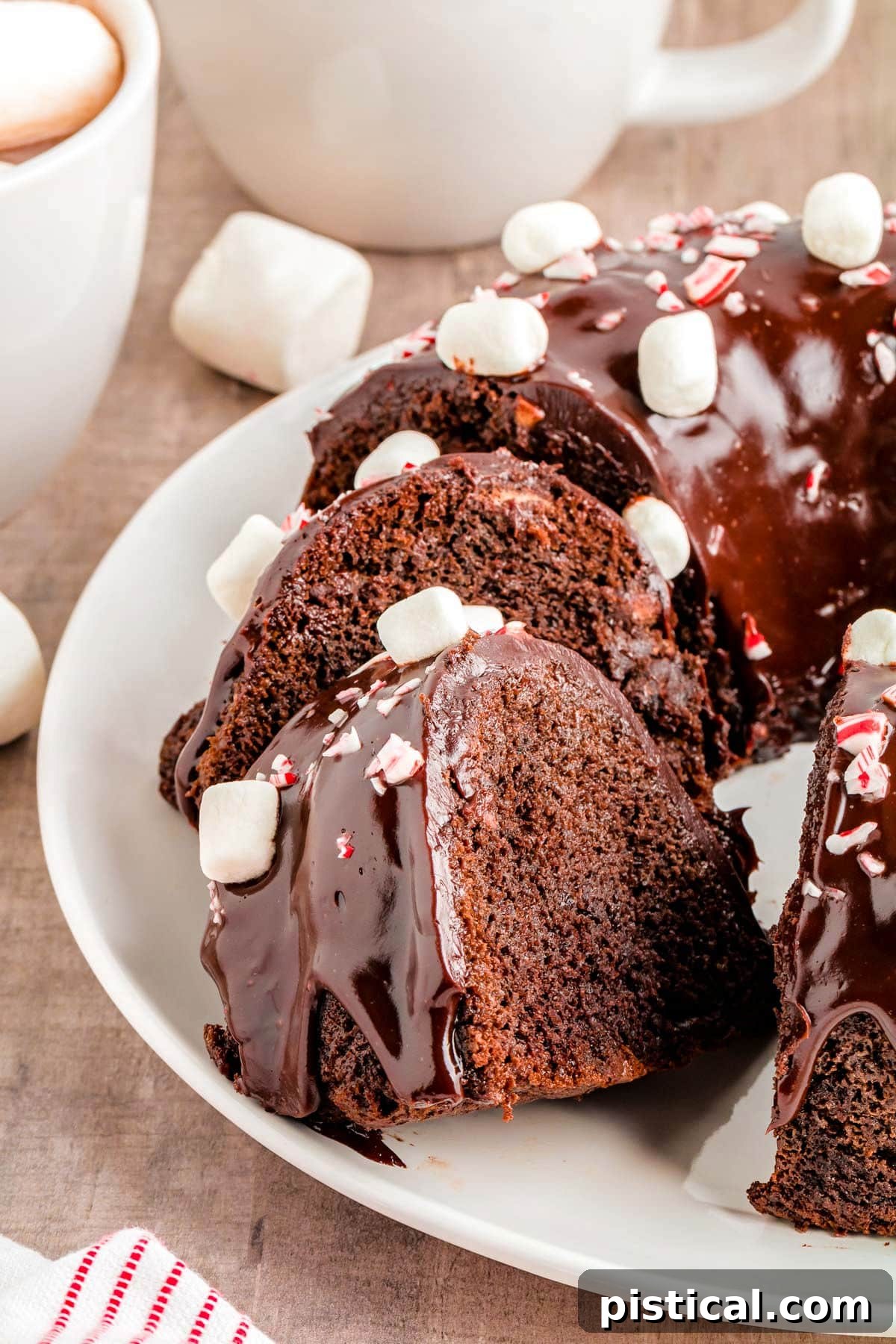 chocolate peppermint bundt cake on white plate with two slices cut out and sat an angle.
